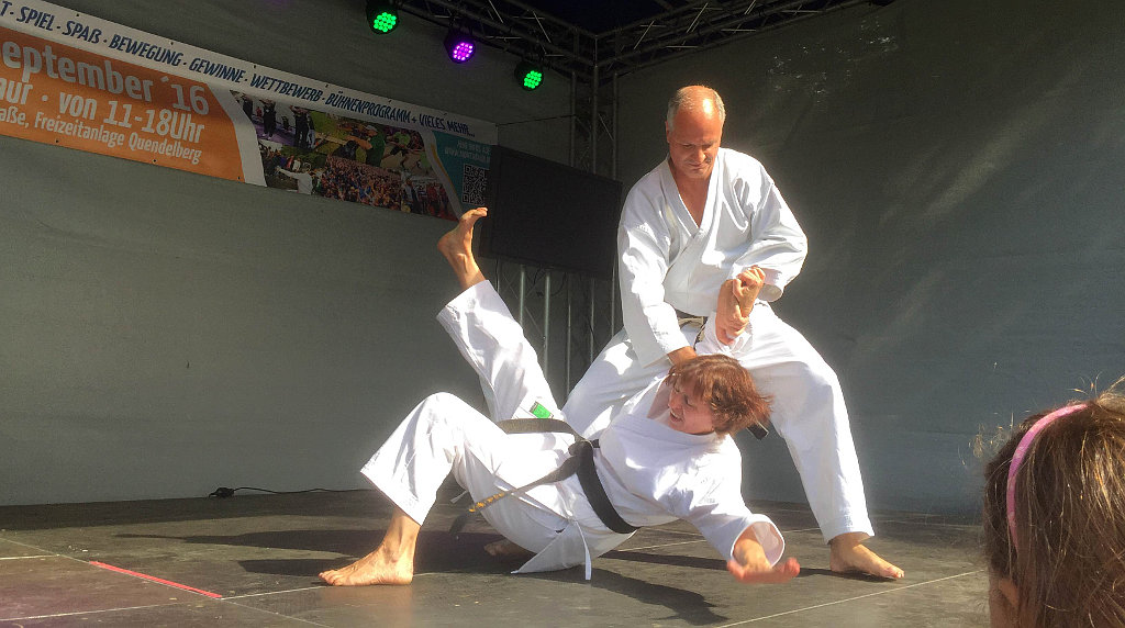 Karateka zeigen fortgeschrittene Partnerübung auf der Bühne