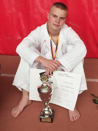 Foto: Alexander Buchheim mit Urkunde und Pokal